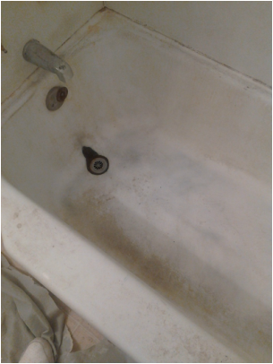 Worn and discolored surface on a porcelain bathtub